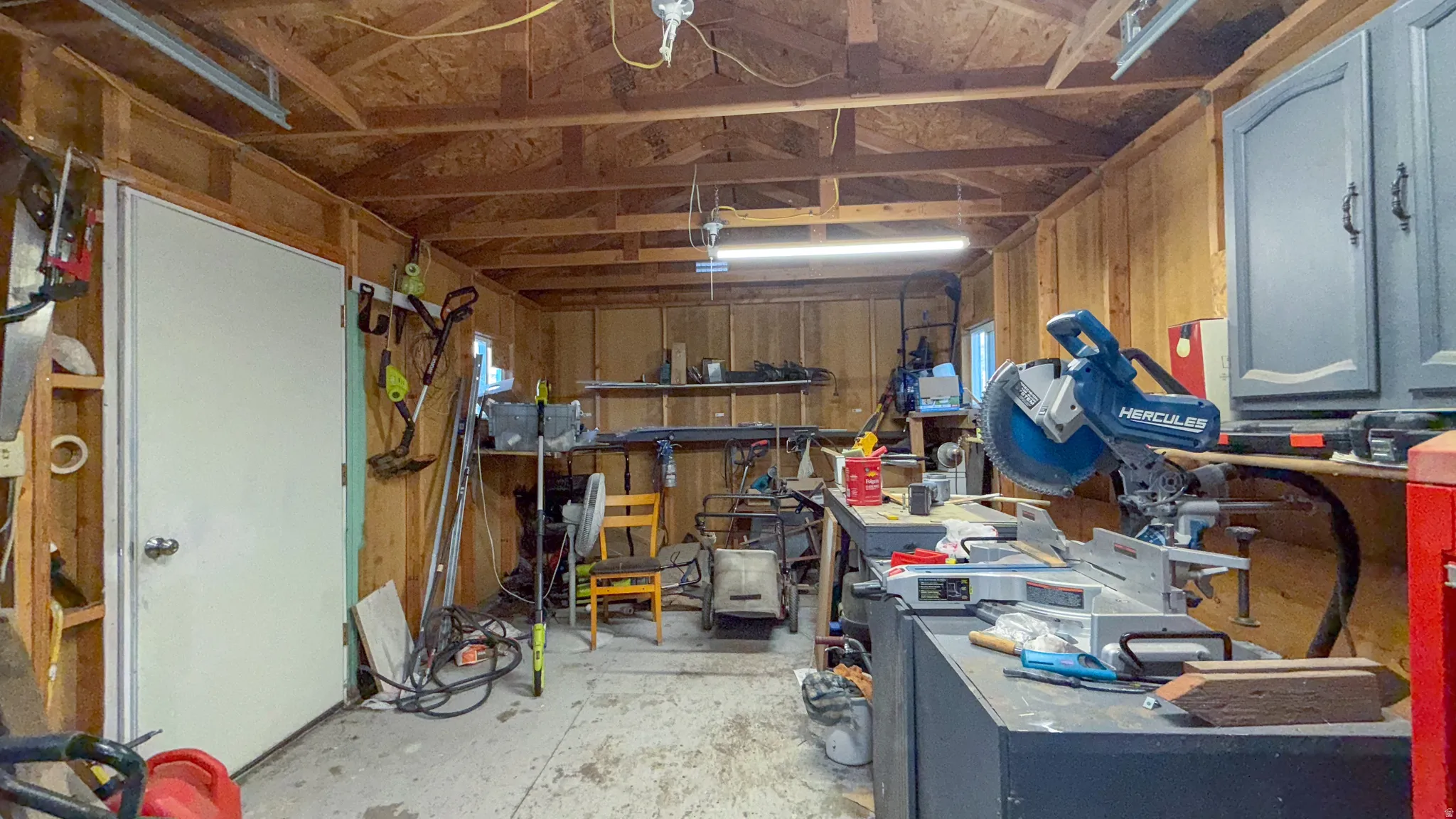 Garage featuring a workshop area and wood walls