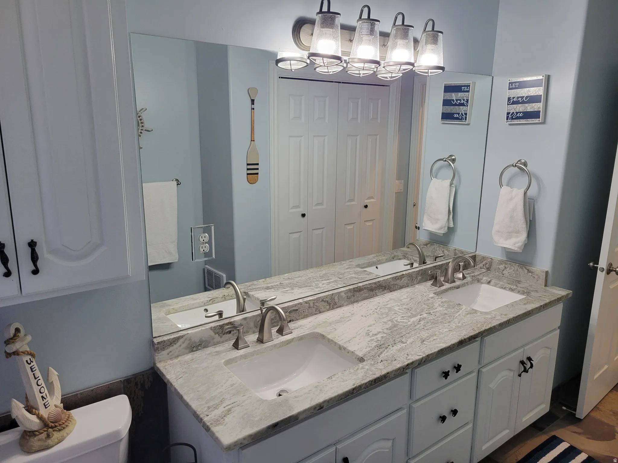Bathroom featuring a closet and double vanity
