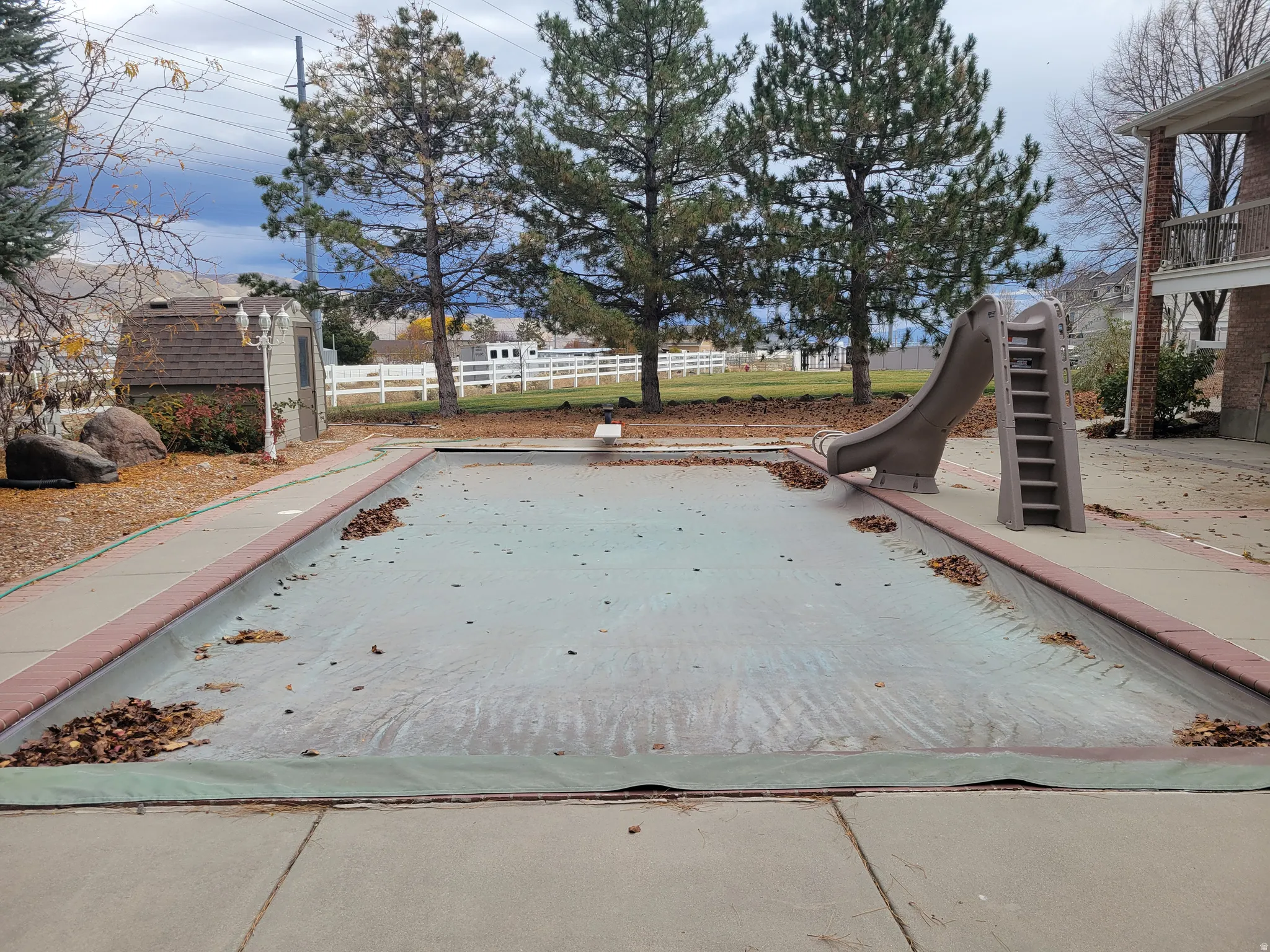 View of swimming pool featuring a water slide, a diving board, and a patio area