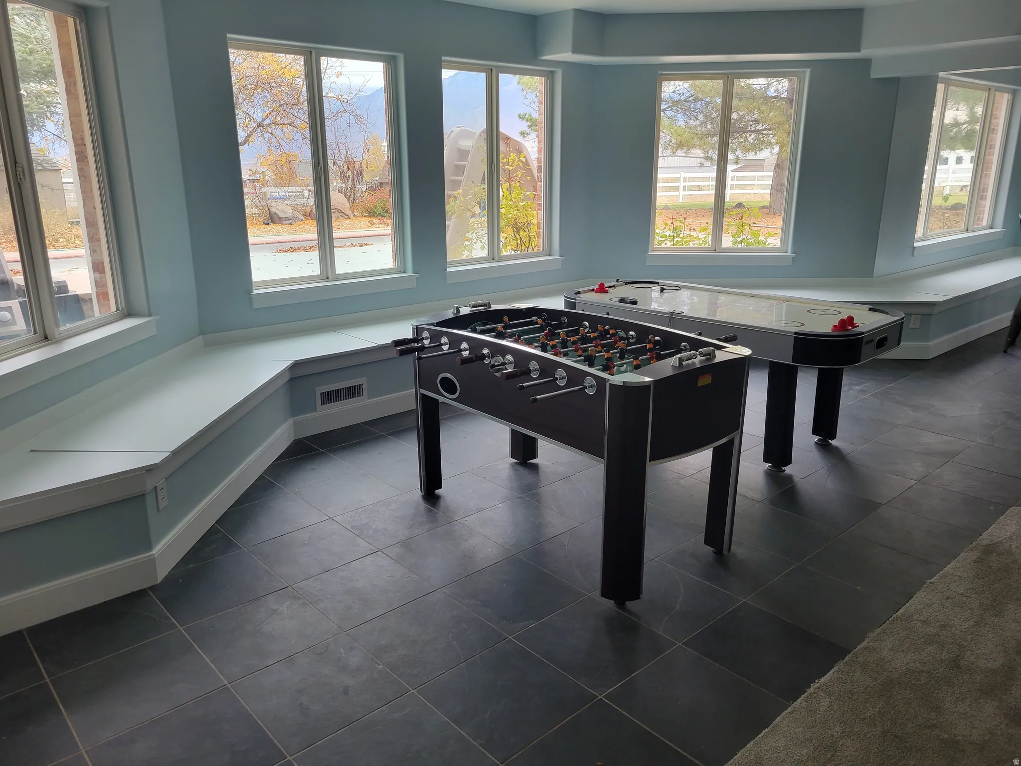 Rec room with dark tile patterned flooring and baseboards