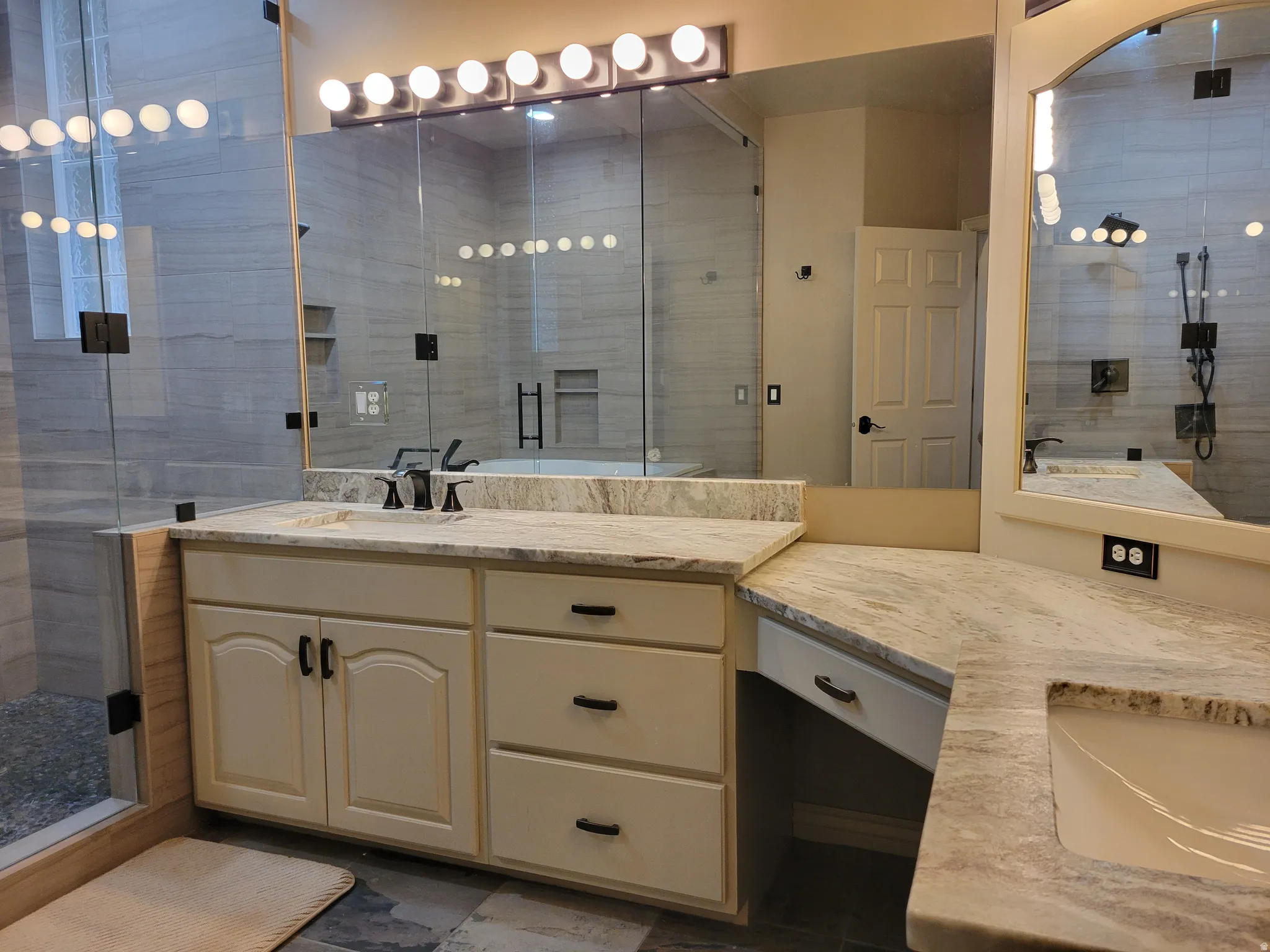 Full bath featuring a shower stall and two vanities