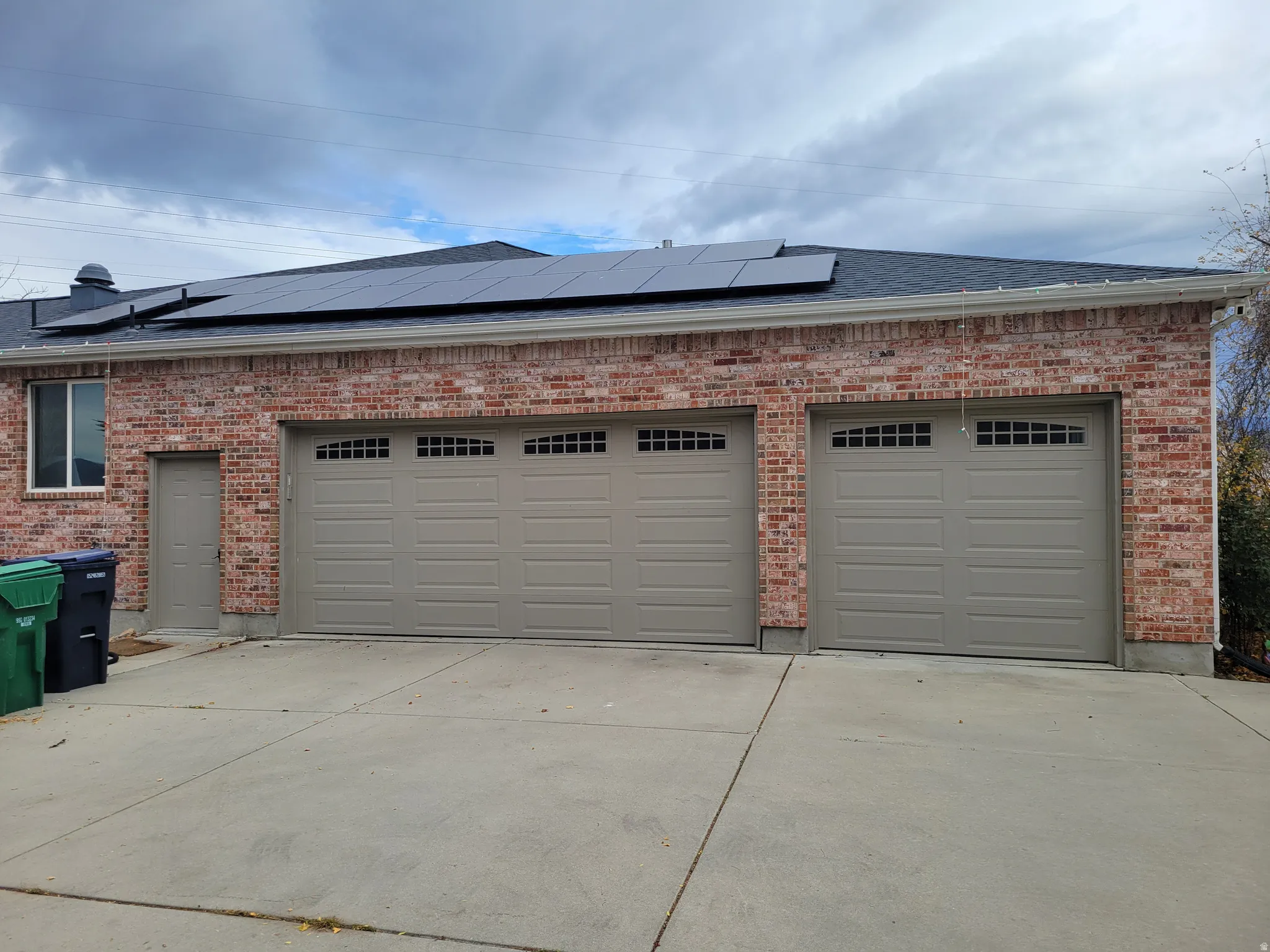 Garage with driveway and solar panels