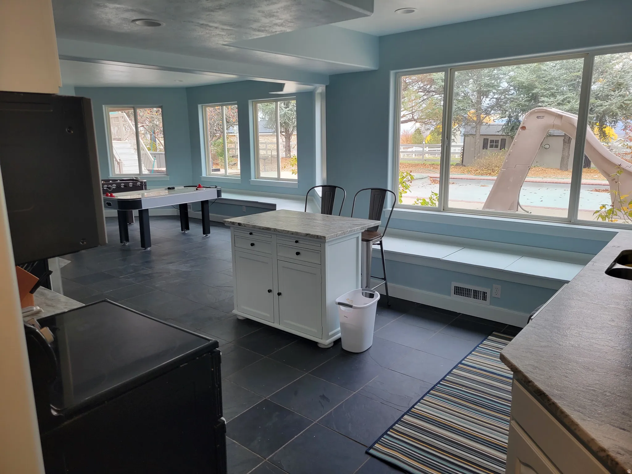 Kitchen featuring white cabinetry, black range, and a kitchen island