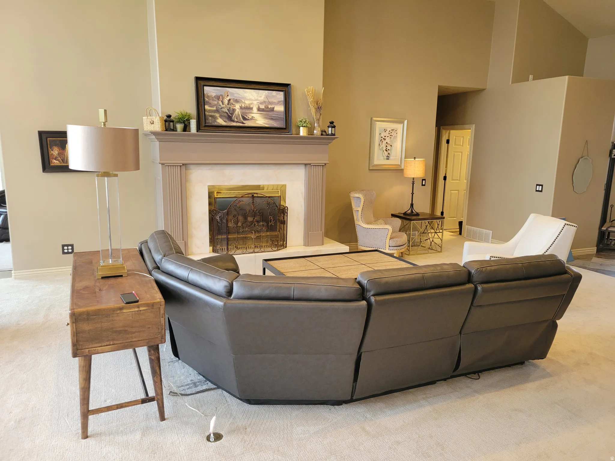 Living area with light carpet, a fireplace, and a high ceiling