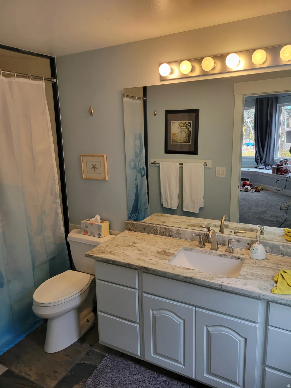 Full bath featuring vanity, a shower with curtain, and dark wood-style floors
