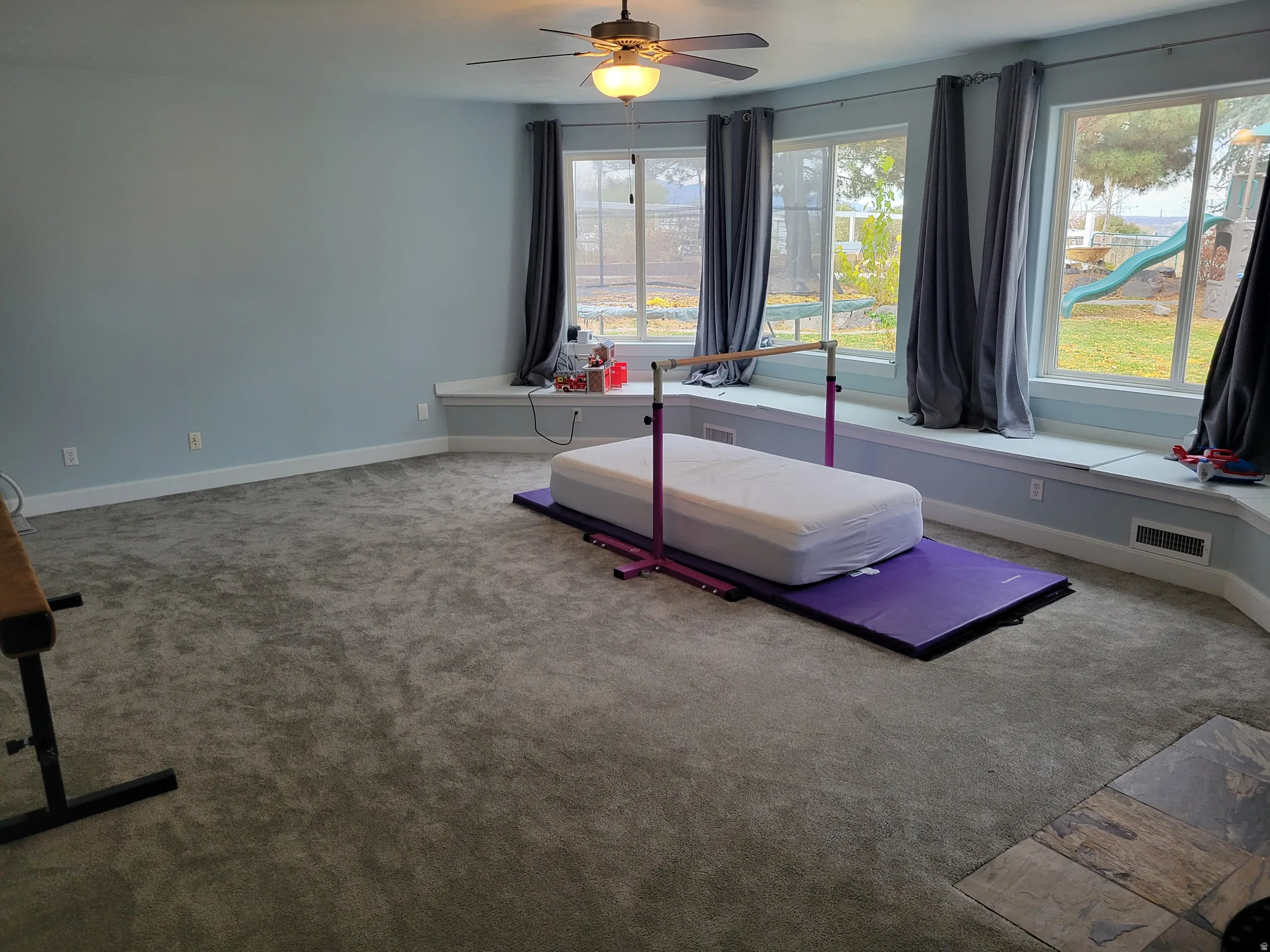 Exercise area with carpet flooring and ceiling fan