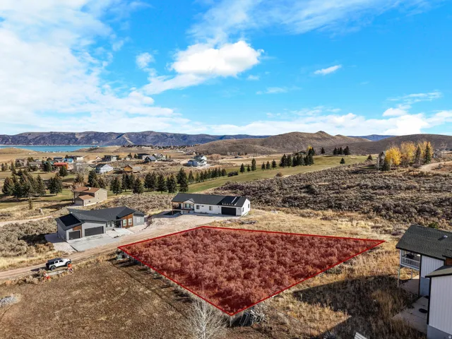 Aerial view of property and surrounding area with property parcel outlined and a water and mountain view