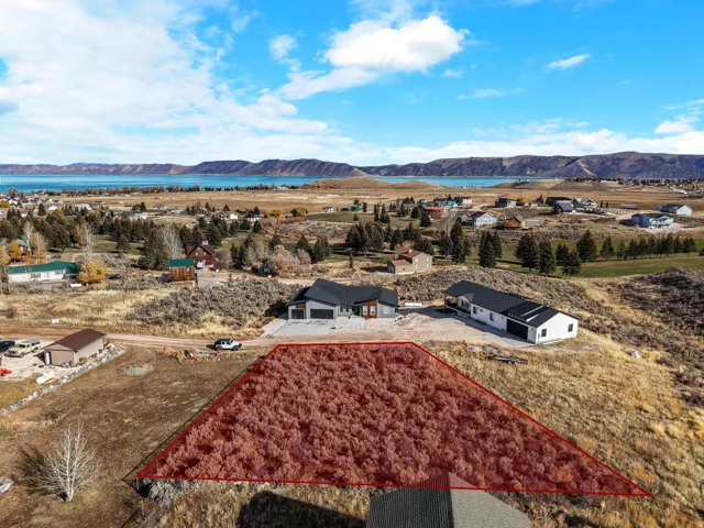 Aerial view of property and surrounding area featuring property boundaries highlighted and a water and mountain view
