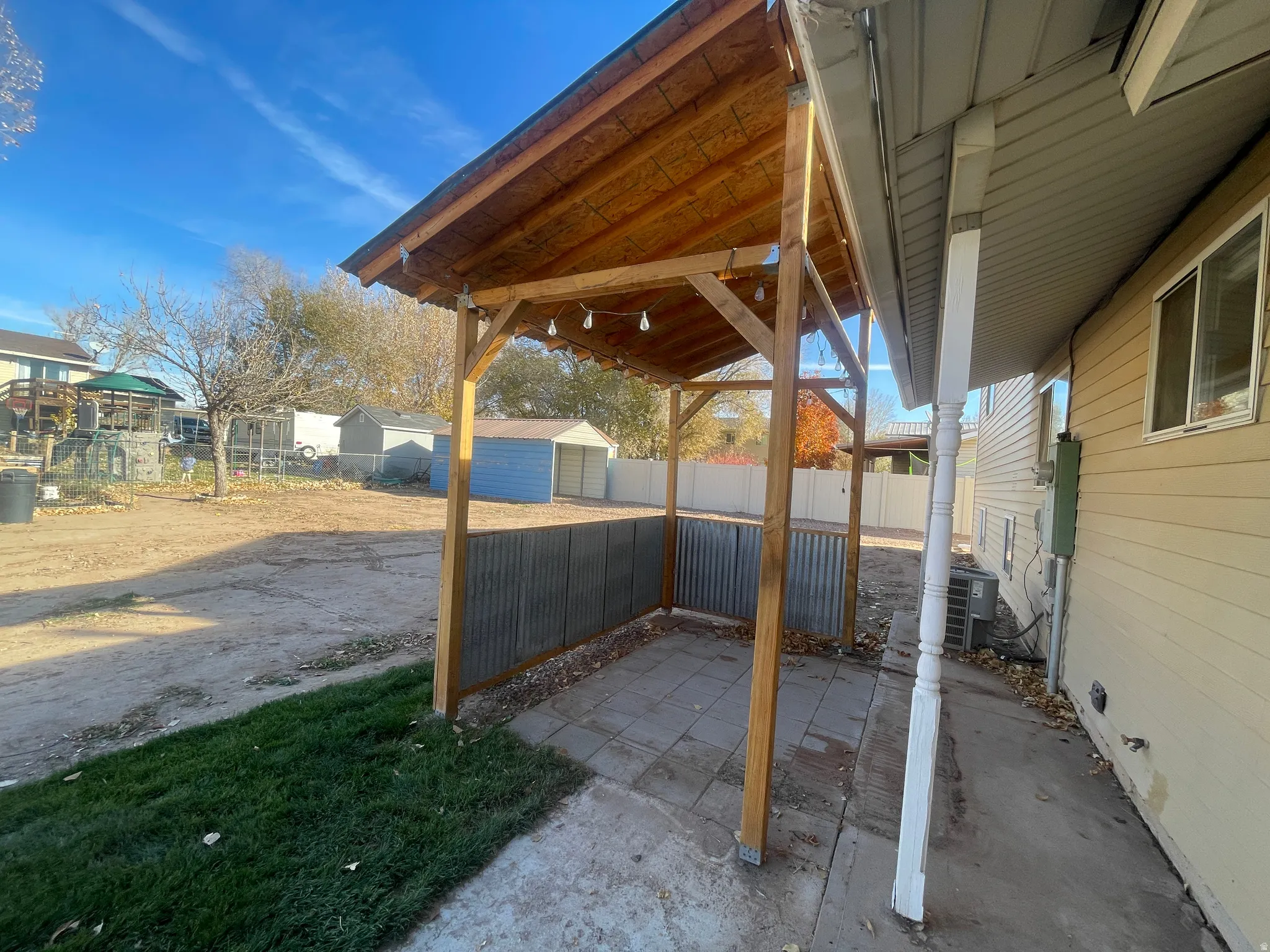 Fenced backyard with a storage shed and a patio area