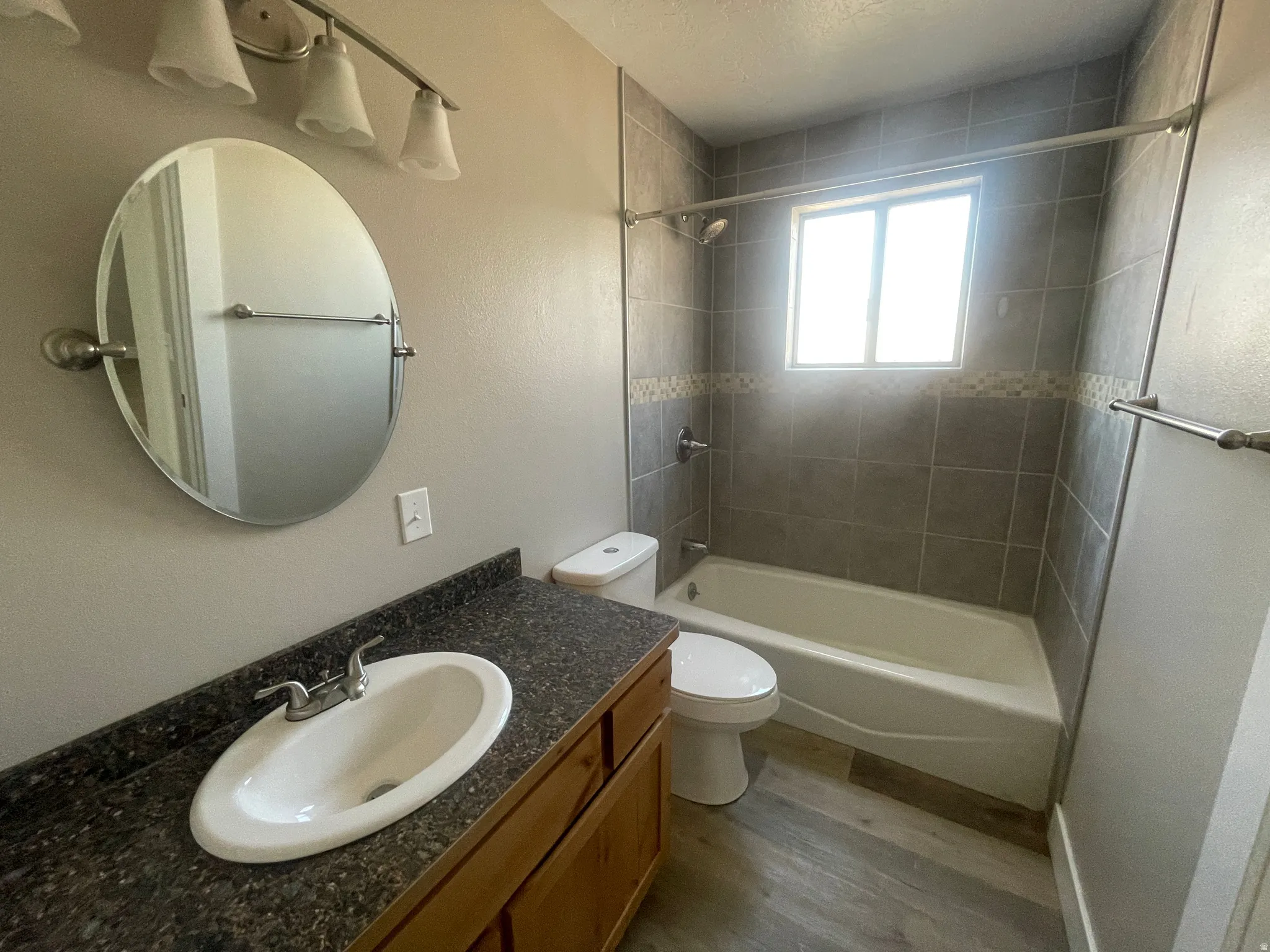 Full bath featuring dark wood-style flooring, vanity, washtub / shower combination, and a textured ceiling