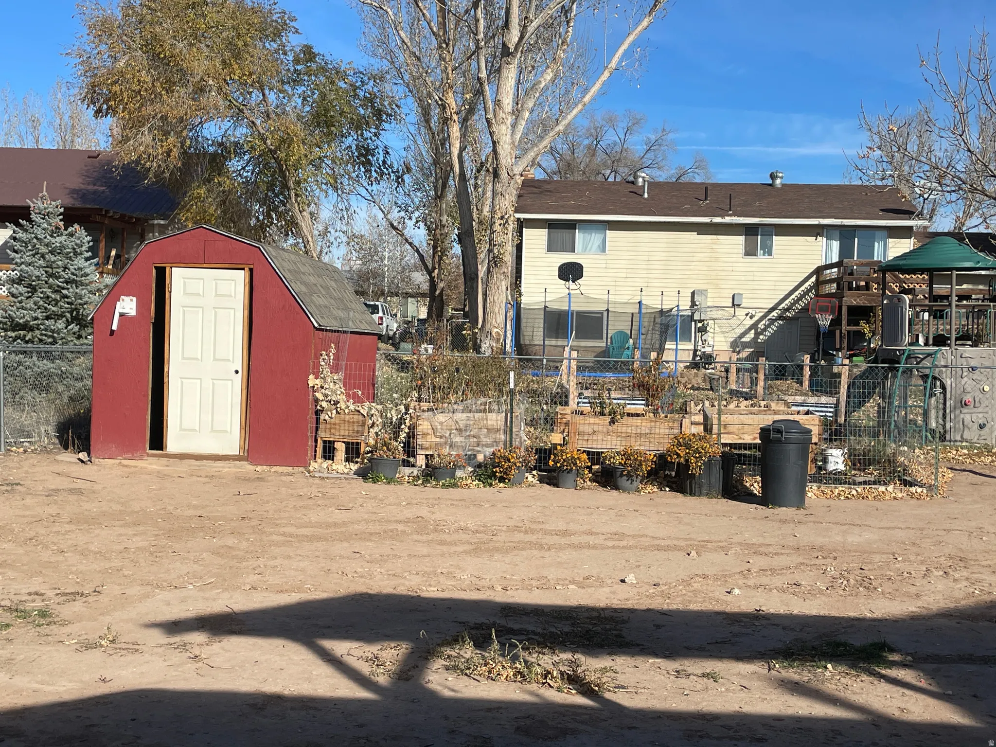 Back of property with a storage shed and a playground