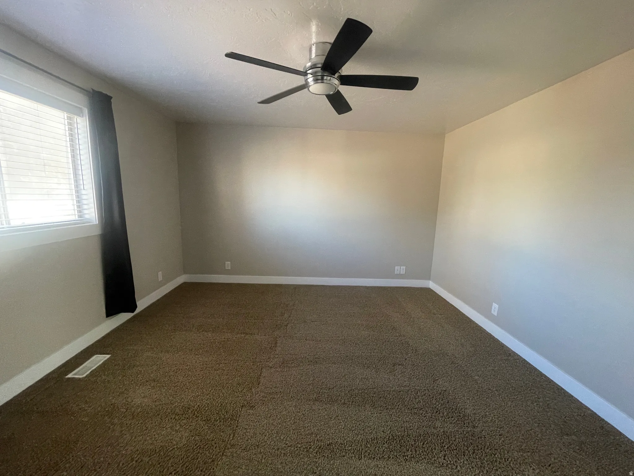 Unfurnished room with carpet floors and a ceiling fan
