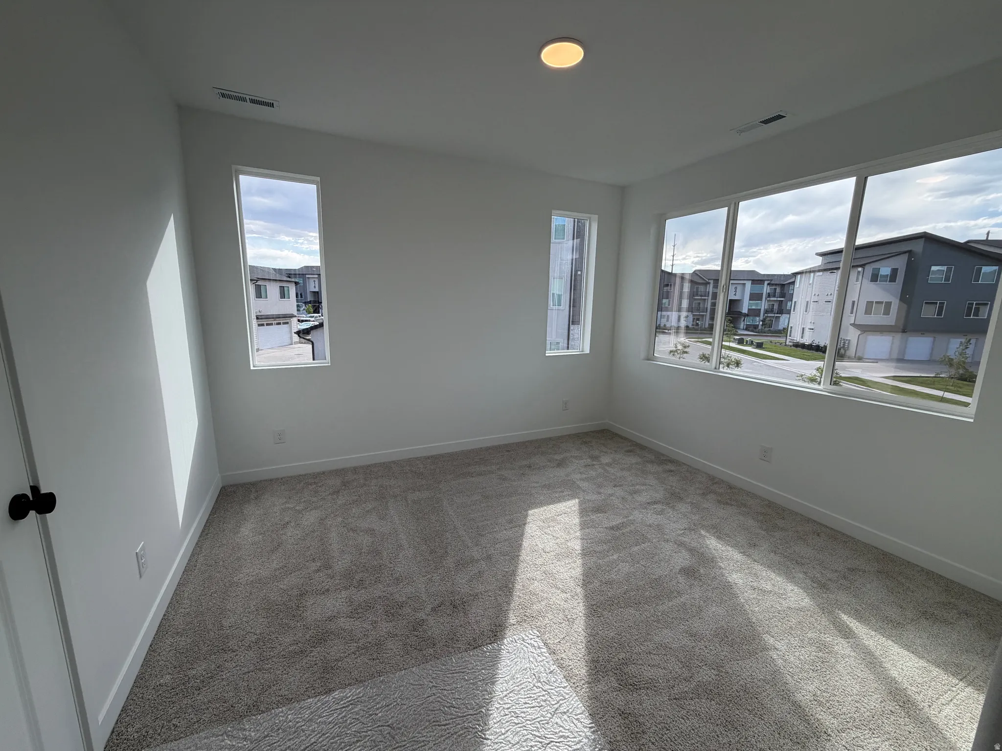 Room featuring light gray carpet flooring, white walls, and white trim