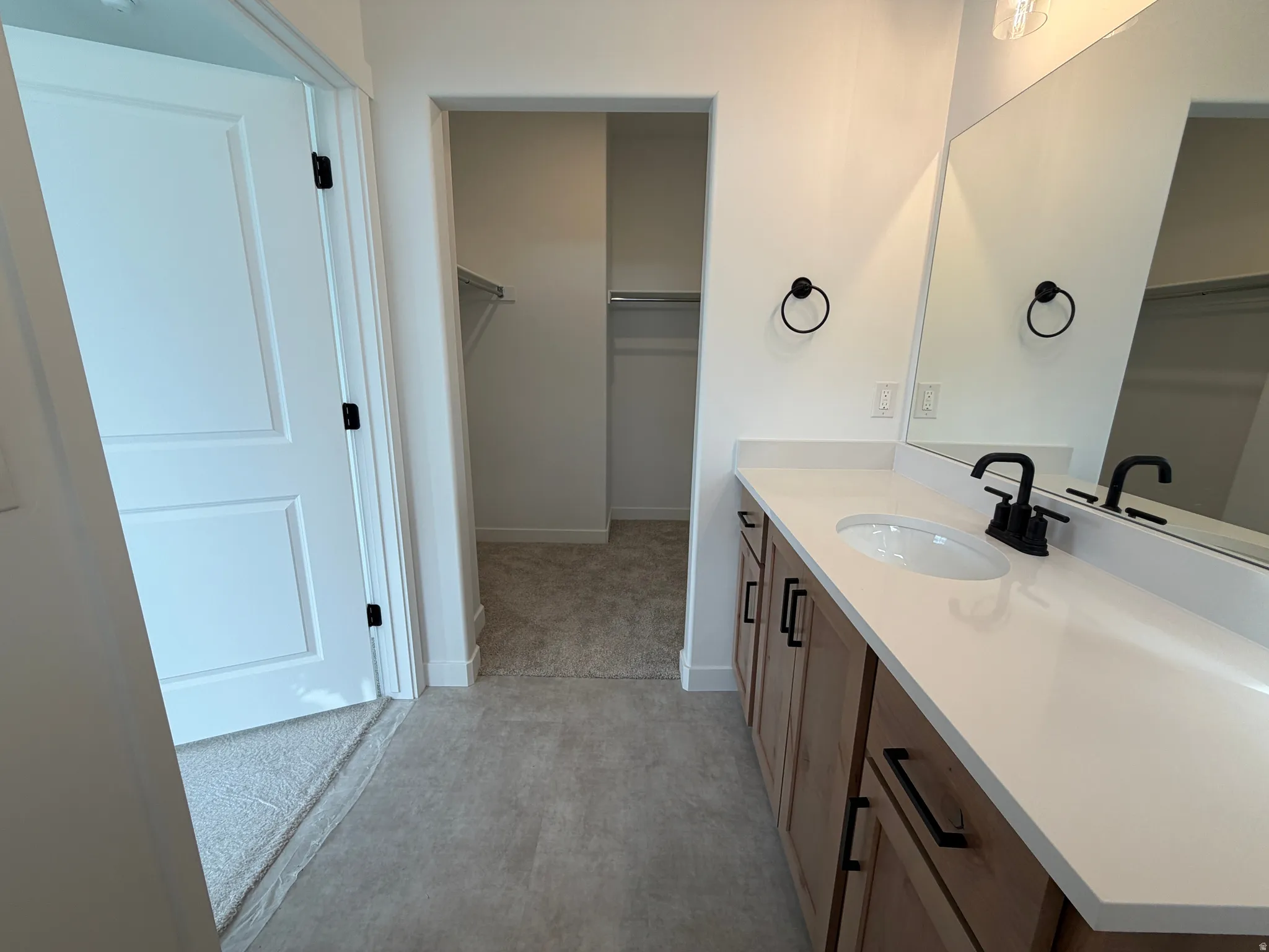 Vanity with a single undermount sink, quartz countertop, and matte black faucet