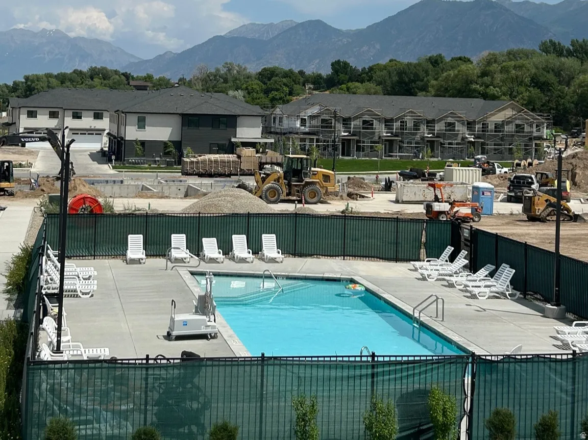 Outdoor swimming pool with concrete decking, perimeter fencing, and lounge chairs