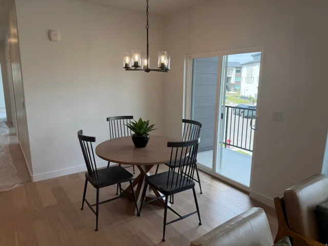 Wood-finish flooring throughout, complemented by a modern chandelier with clear glass shades