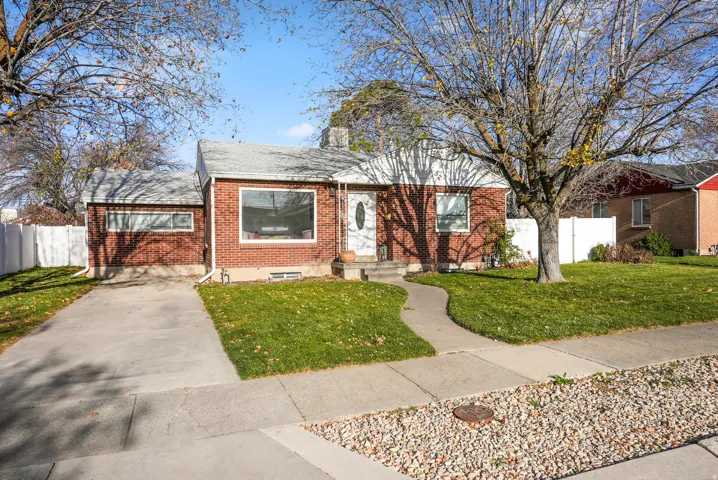 View of front of house featuring brick siding, a shingled roof, and driveway