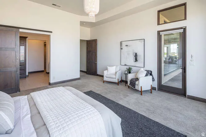 Carpeted bedroom with baseboards and access to exterior