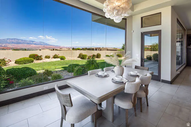 Dining space with a chandelier, light tile patterned floors, and a tray ceiling