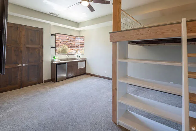 bedroom featuring light carpet and a ceiling fan