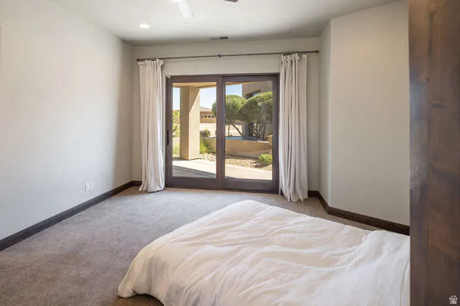Bedroom featuring light carpet, access to outside, and ceiling fan