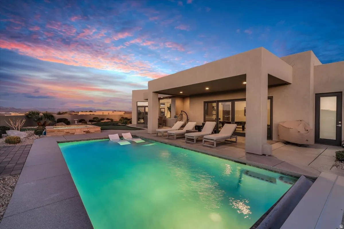 Pool at dusk with a patio area