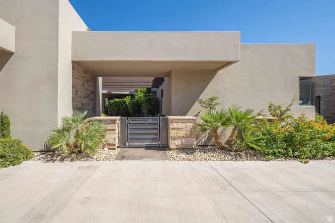 Property entrance featuring a gate and stucco siding
