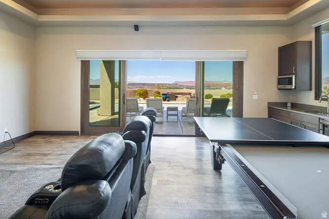 Playroom featuring light wood finished floors and a tray ceiling