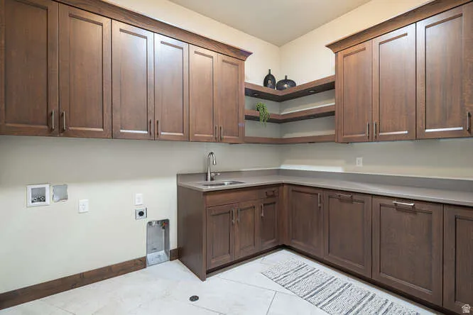 Laundry room with electric dryer hookup, cabinet space, light tile patterned floors, and washer hookup