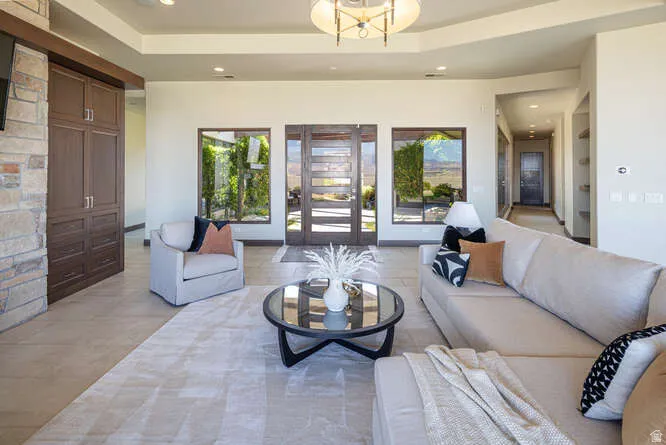 Living area featuring a raised ceiling and recessed lighting
