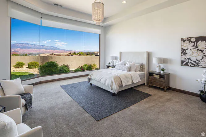 Carpeted bedroom featuring a mountain view and a tray ceiling