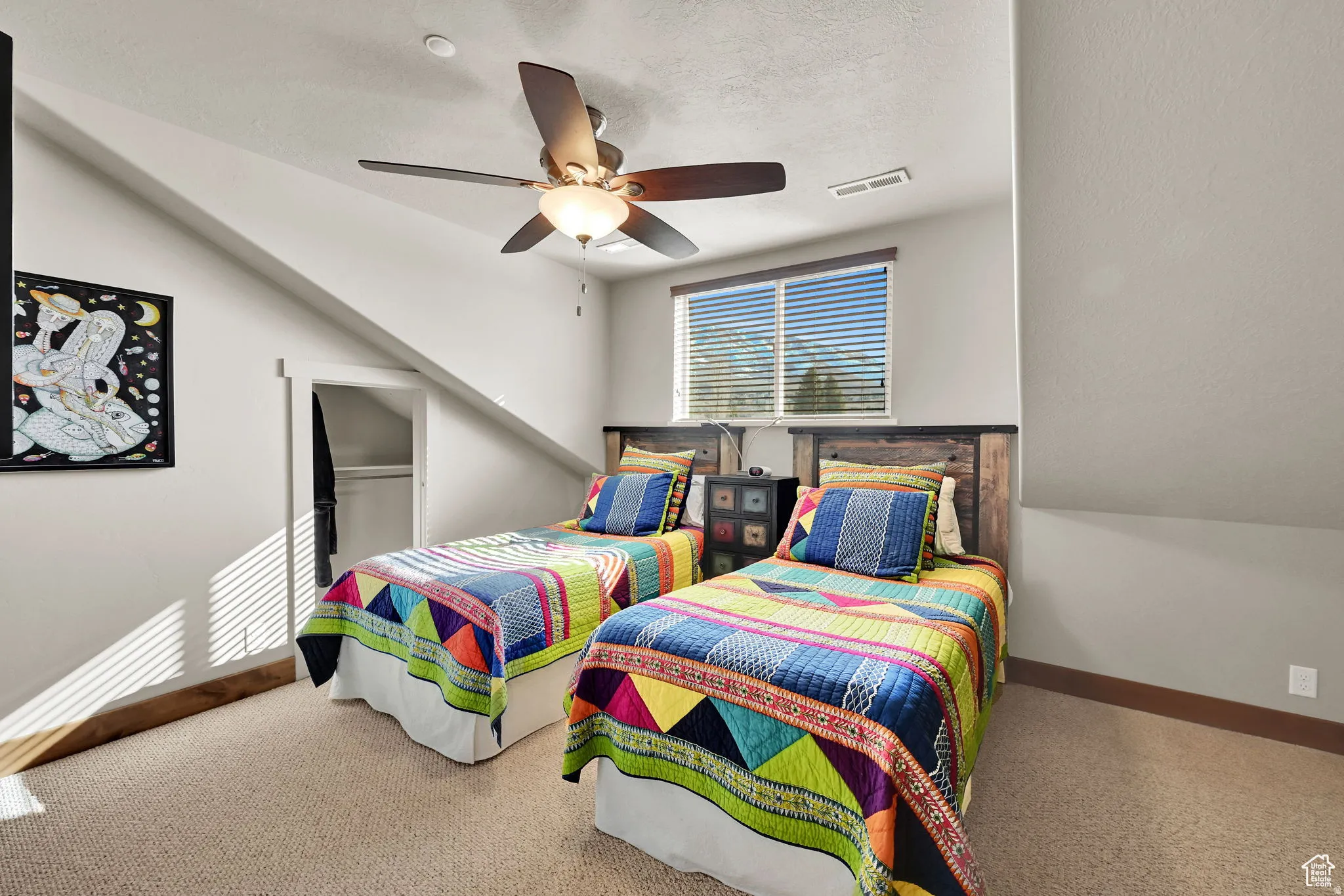Carpeted bedroom featuring a ceiling fan and a textured ceiling