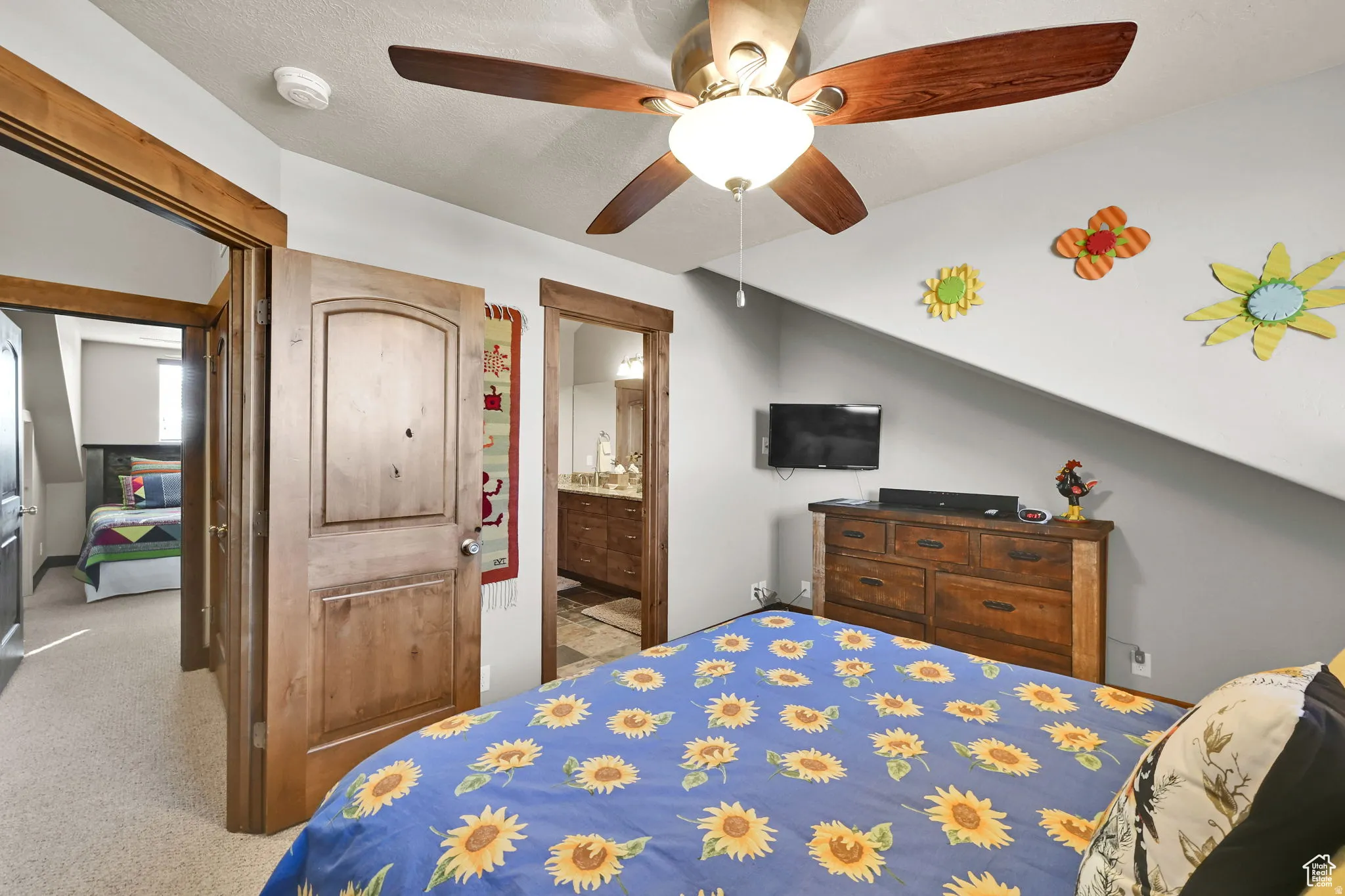 Bedroom with connected bathroom, carpet floors, and a ceiling fan