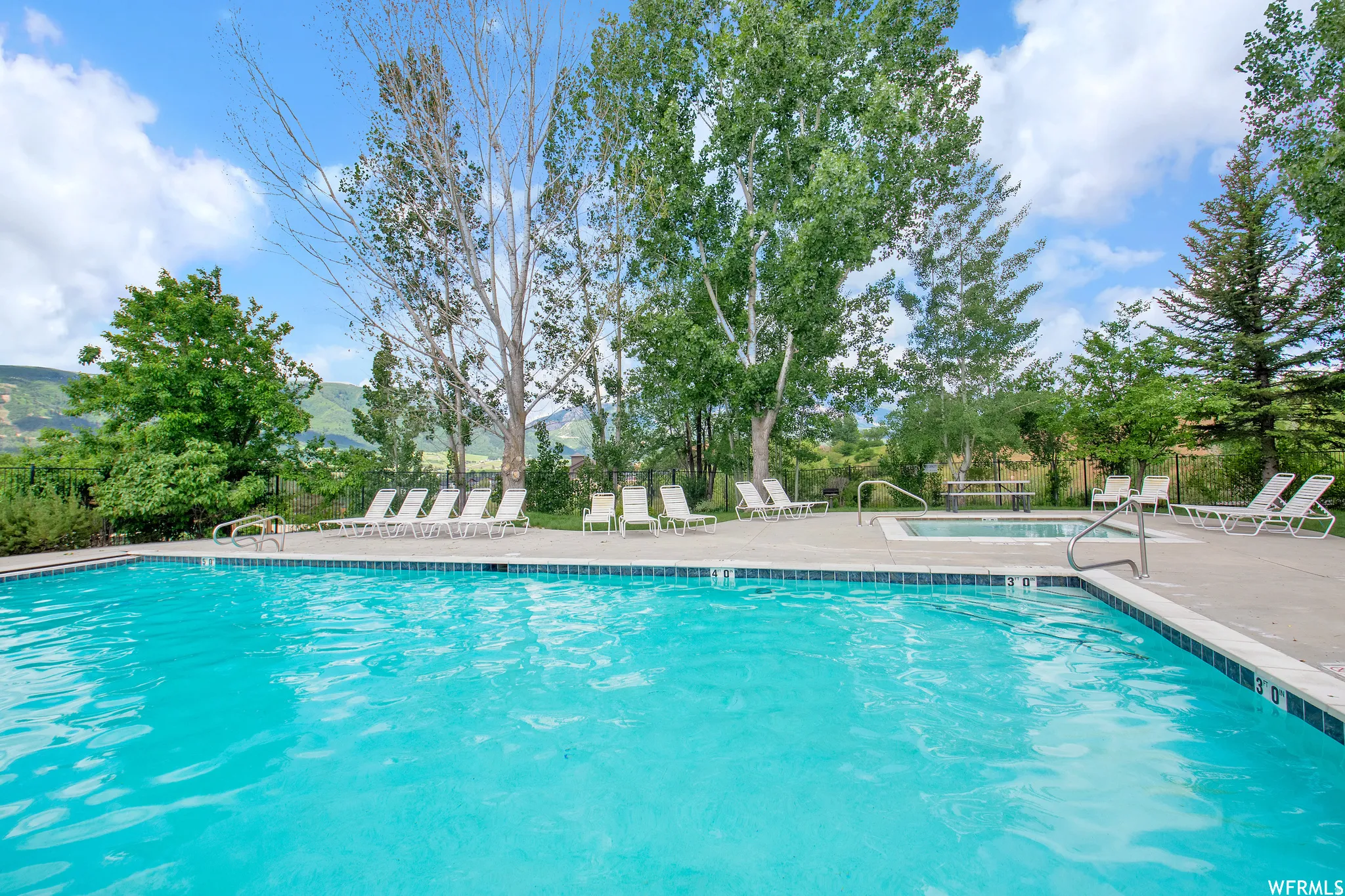Community pool with a patio area and a mountain view