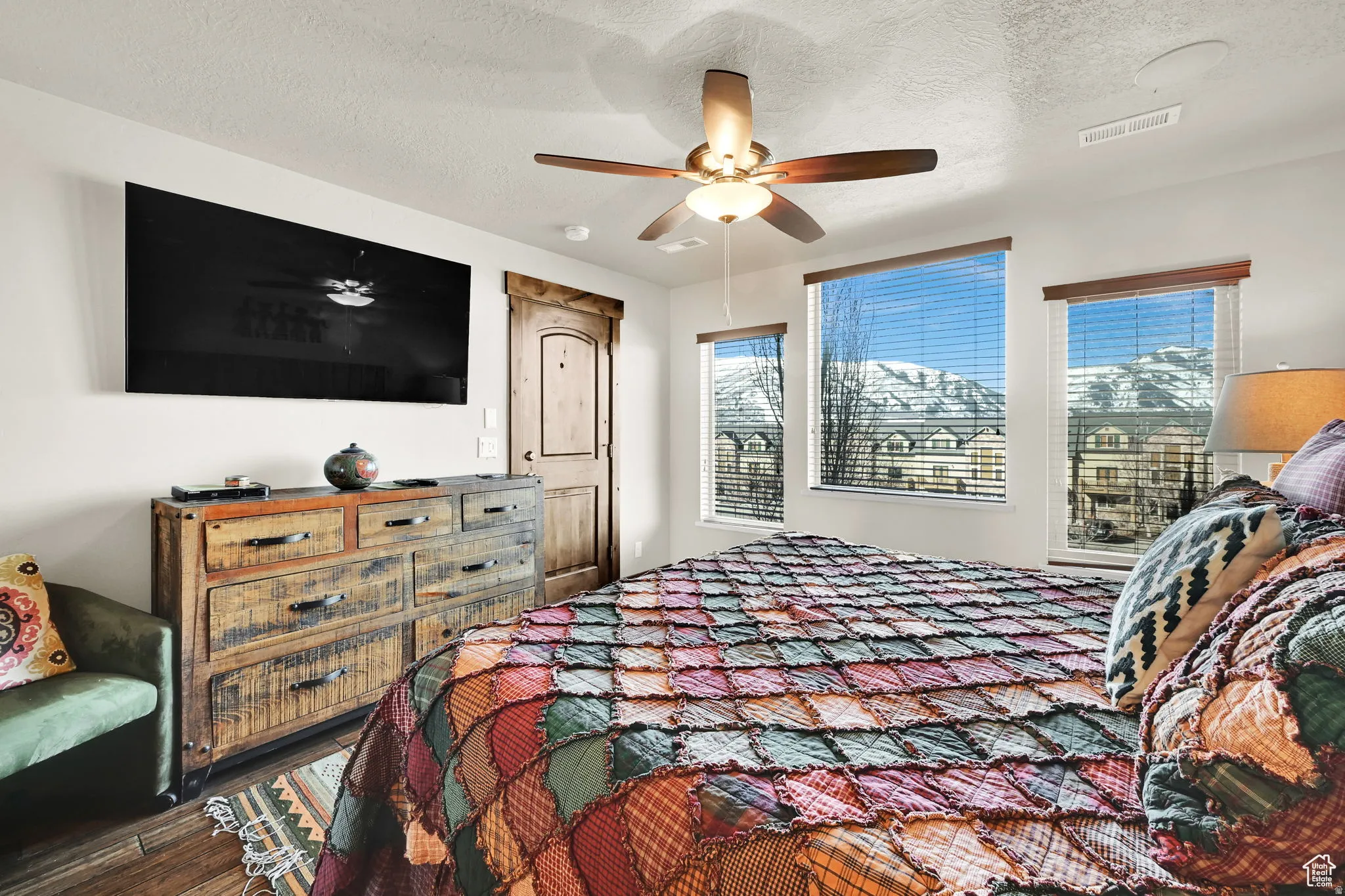Bedroom featuring wood finished floors, a textured ceiling, and ceiling fan
