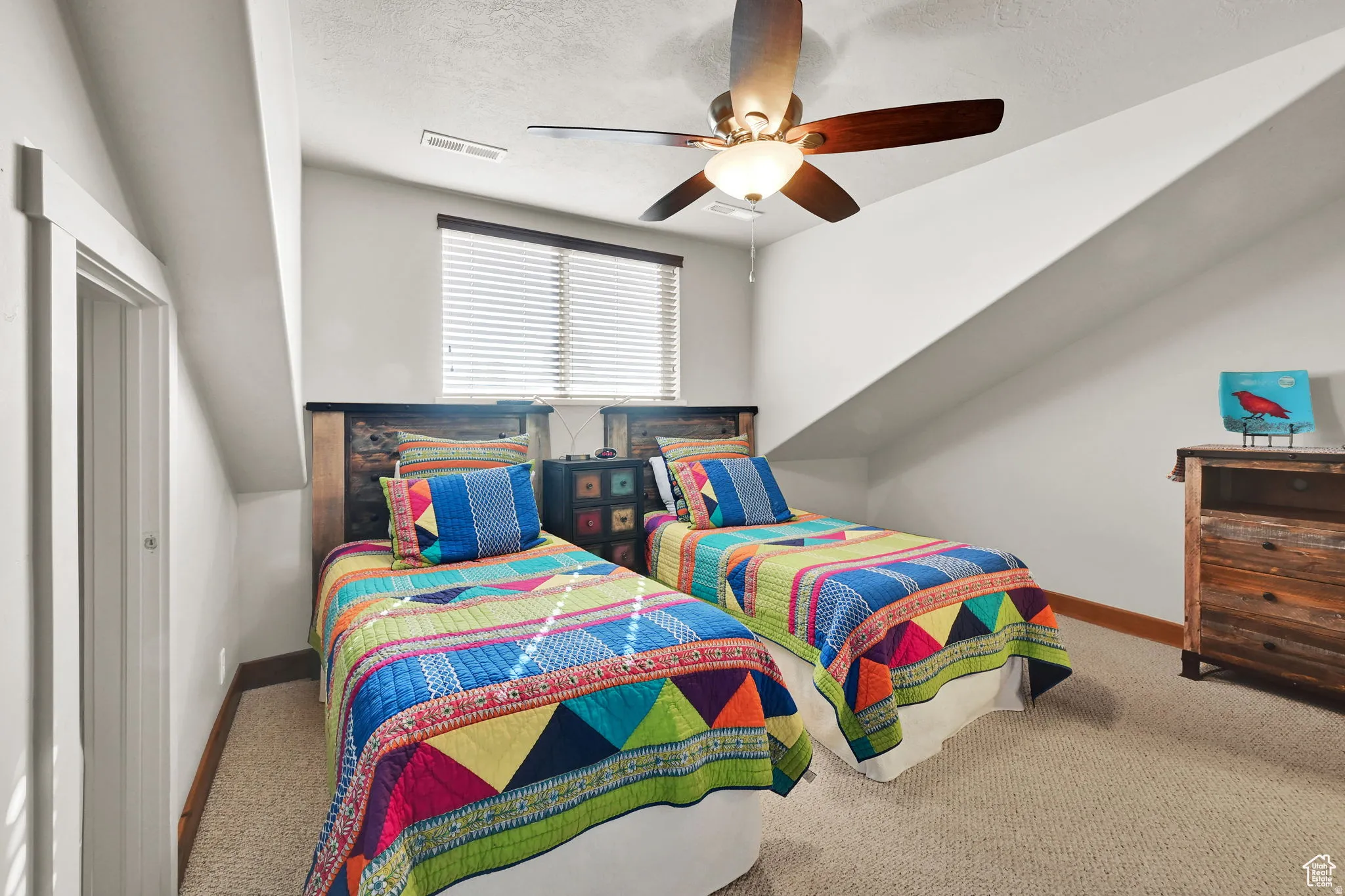 Carpeted bedroom featuring ceiling fan and a textured ceiling
