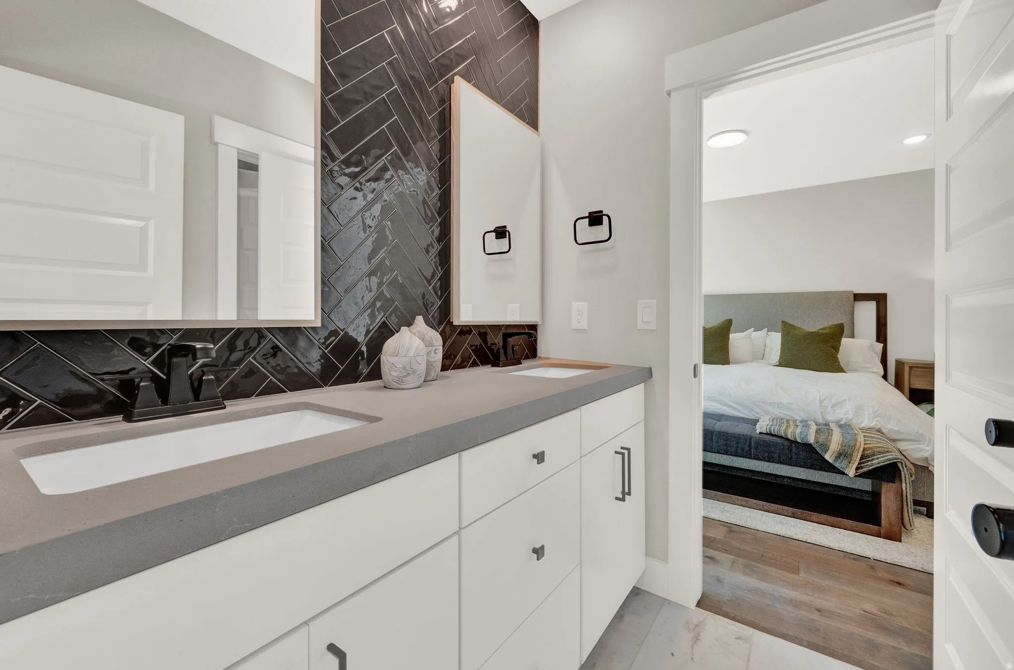 Bathroom featuring backsplash, double vanity, light wood finished floors, and recessed lighting