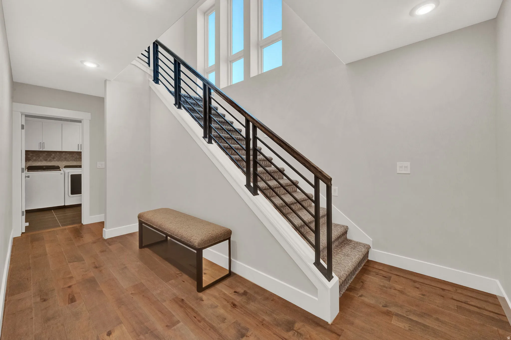 Staircase featuring recessed lighting, wood finished floors, and independent washer and dryer