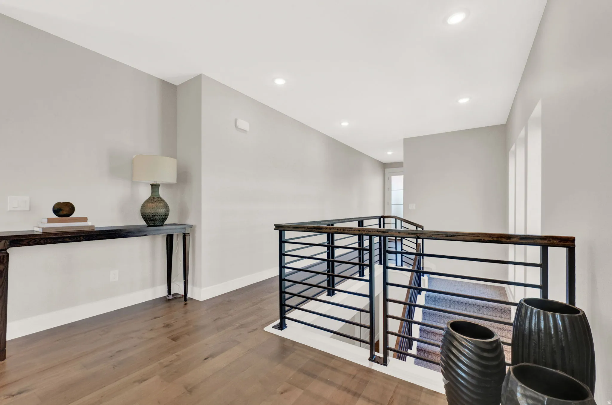Hall featuring recessed lighting, light wood-type flooring, and an upstairs landing