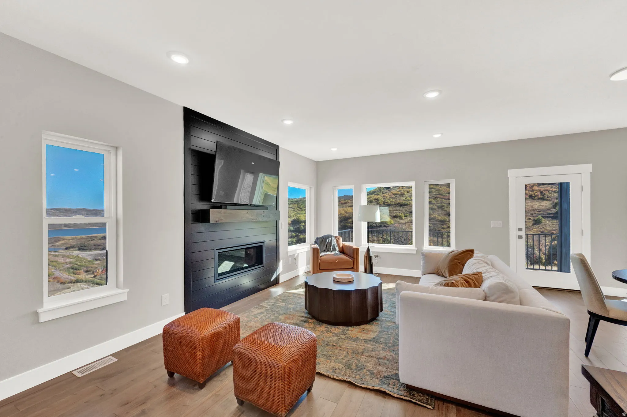 Living room with a large fireplace, light wood-style floors, and recessed lighting