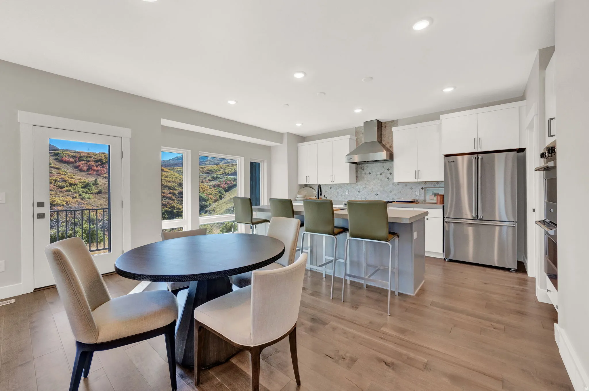 Dining room with light wood-style floors and recessed lighting