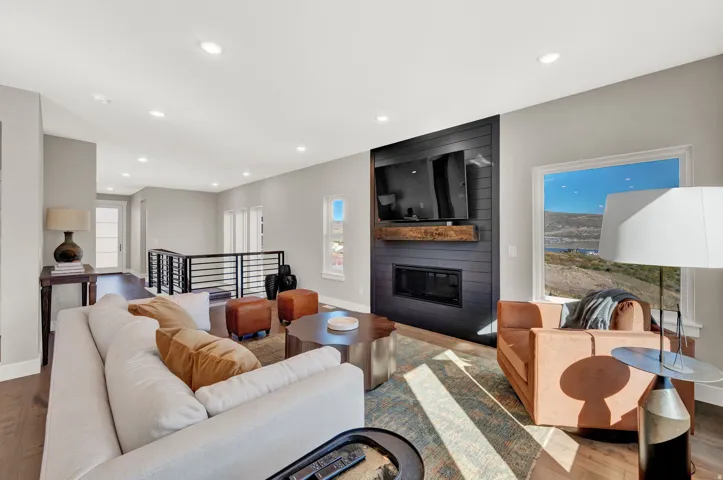 Living room featuring wood finished floors, recessed lighting, and a large fireplace