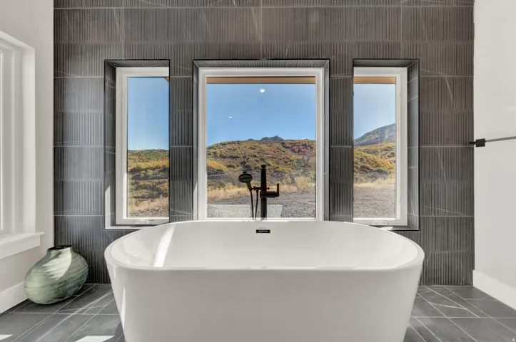 Full bath with a soaking tub, a mountain view, and tile patterned flooring