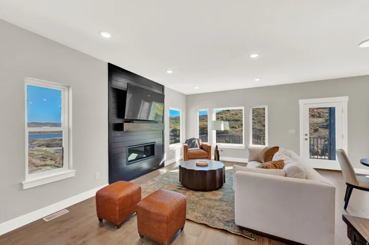 Living room with a large fireplace, light wood-style floors, and recessed lighting