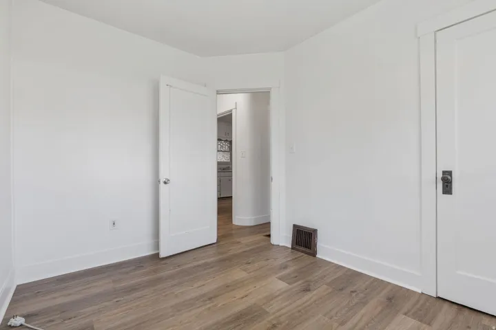 Unfurnished bedroom featuring wood finished floors and baseboards