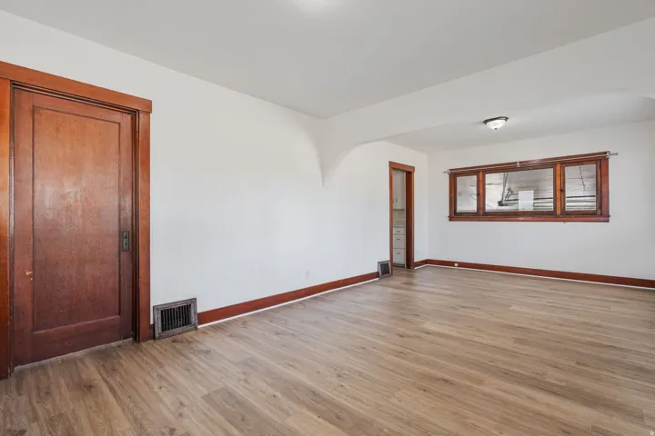 Unfurnished room with light wood-type flooring and arched walkways