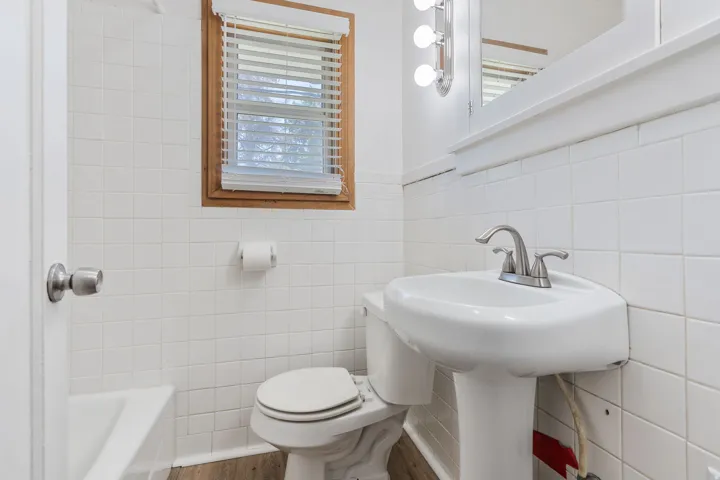 Bathroom featuring tile walls and wood finished floors