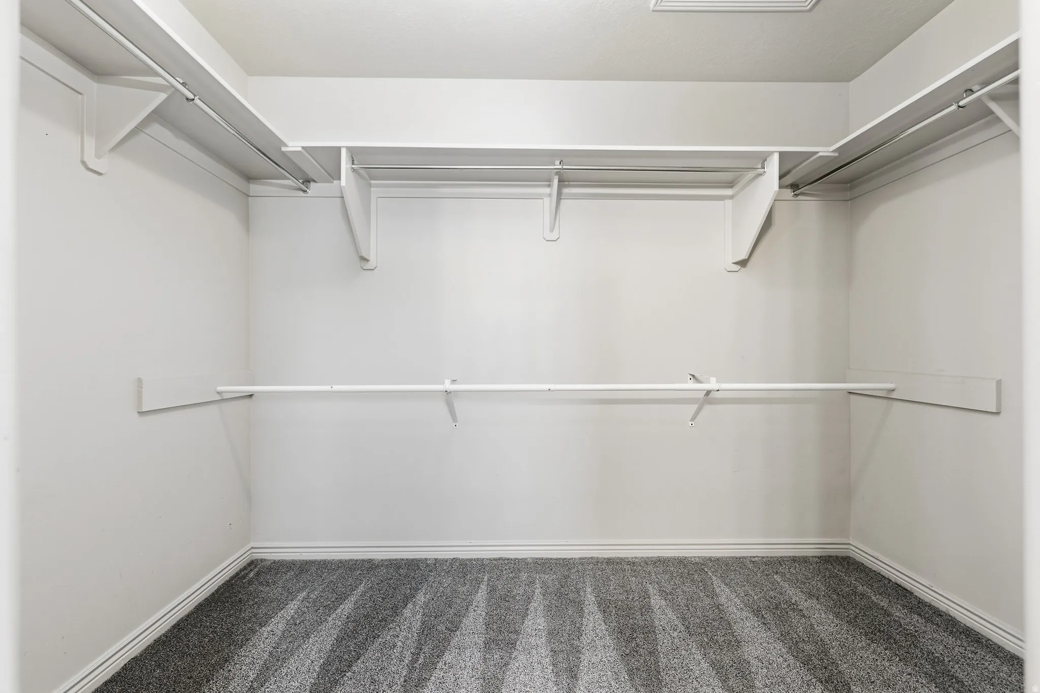 Spacious closet with dark carpet