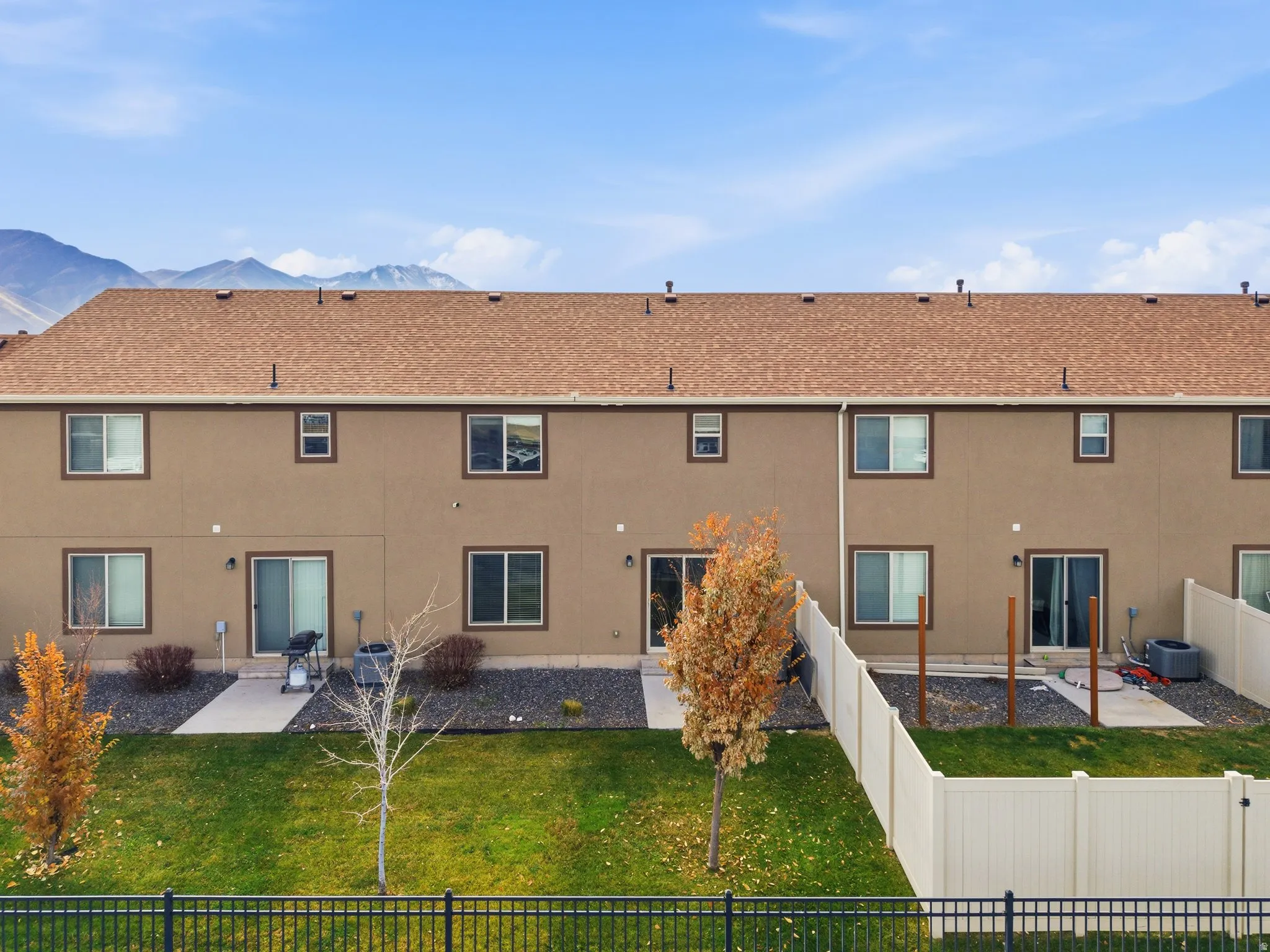 Back of house with a patio, stucco siding, a fenced backyard, and a shingled roof