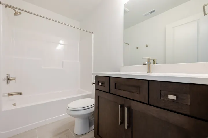 Full bath featuring vanity, bathing tub / shower combination, and light tile patterned floors